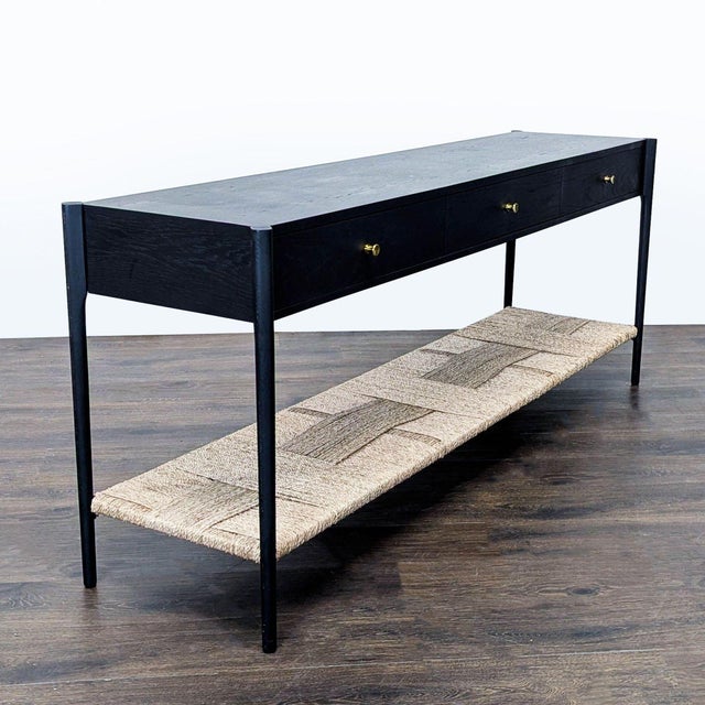 Three drawer table with brass hardware and woven rope shelf. Brand: Arhaus. Dimensions (in): 72W x 18D x 29H.