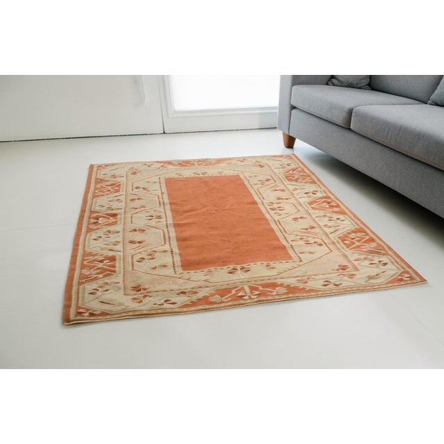 This is a vintage Turkish Oushak rug from the Mid 20th Century. The piece was hand-knotted.