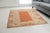 This is a vintage Turkish Oushak rug from the Mid 20th Century. The piece was hand-knotted.