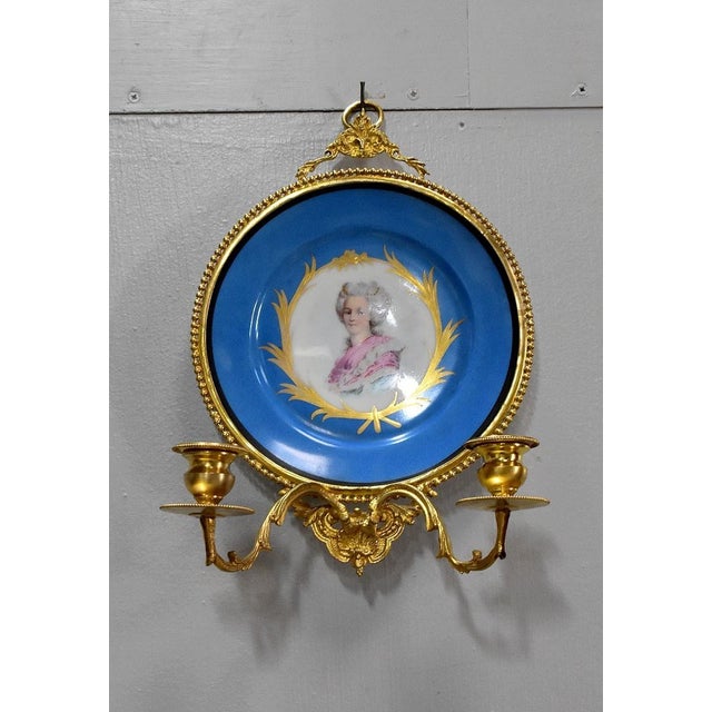 Pair of Louis XVI style brass wall lights with two sconces decorated with foliage for candlesticks. They are made up of a...