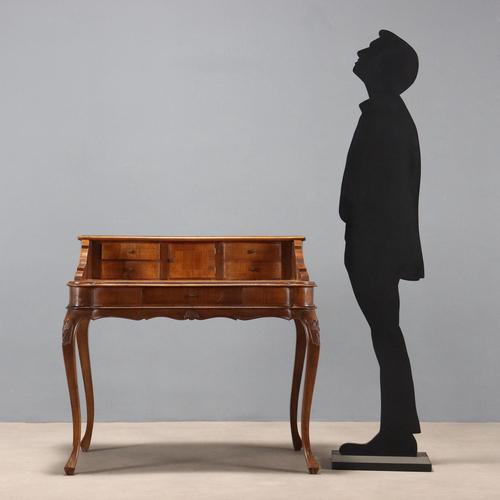 Late Baroque-style walnut writing desk. The raised part features a curved front, a central door, and pairs of side...