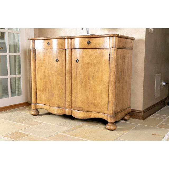 A large-scale, extremely well-crafted and solid cabinet with a curvaceous hand-carved, two-door serpentine front, two...