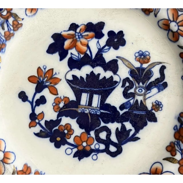 A 19th century Imari chinoiserie style flow blue plate. With a Japanese vase and iron red flowers and touches of gold...
