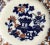A 19th century Imari chinoiserie style flow blue plate. With a Japanese vase and iron red flowers and touches of gold...
