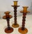Set of three amber colored er colored glass candlesticks in varying hights. 3.75 x 8, 3.75 x 9.50 and 3.75 x 11