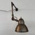 This mid 20th century industrial articulating task lamp features a brushed steel exterior finish and painted white...