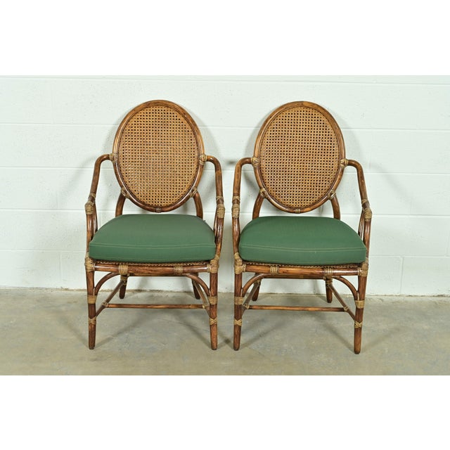 A gorgeous pair of Hollywood Regency Organic Modern bamboo and cane armchairs or dining captain chairs By McGuire of San...