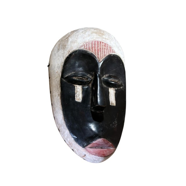 Superb vintage Fang mask carved from a single piece of heavy wood, featuring an elongated heart-shaped face rendered in...