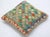 A one-of-a-kind handwoven Afghan wool kilim accent pillow featuring a diamond lattice grid in vivid green, red, and blue....
