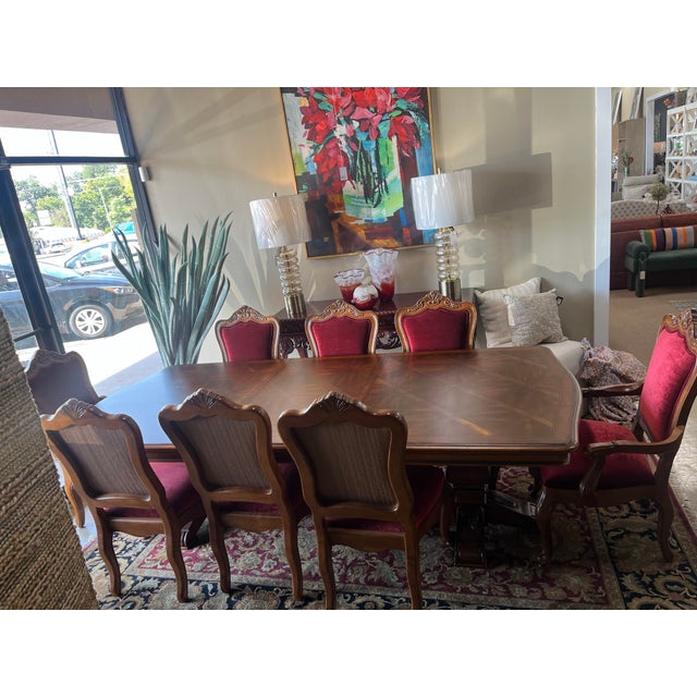 Beautiful inlaid wood dining table with double pedestal base. 8 chairs upholstered in a berry-red velvet front and brown...