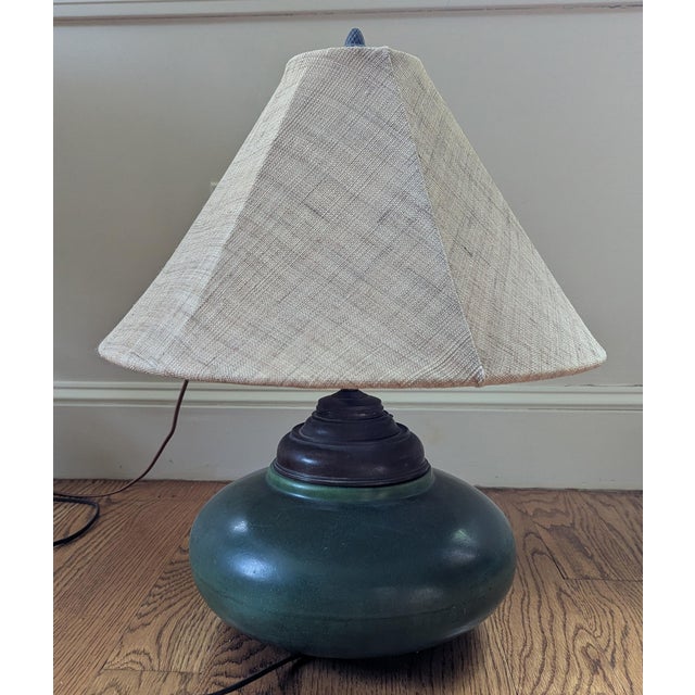 Hampshire ceramic lamp with a globed form and matte green glaze. Metal details and acorn finial. Shade not included;...