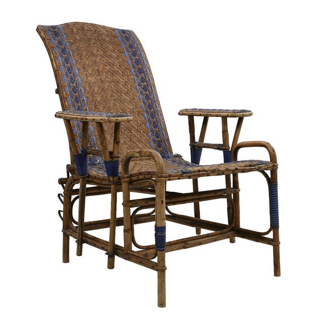 Rattan long chair, from the beginning of the 20th century. Its solid rattan structure, embellished with blue patterns,...