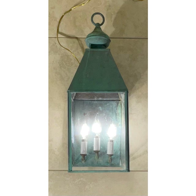 exquisite, oversized wall-mount lantern. Crafted from heavy-duty solid brass, this fixture features a natural, weathered...