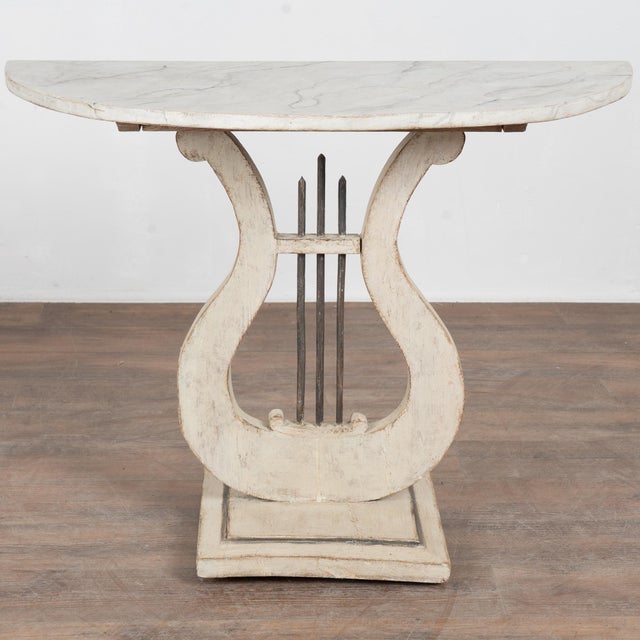 19th-century Swedish pine console table in a demilune, or half-circle form with a harp-shaped base. The table retains an...