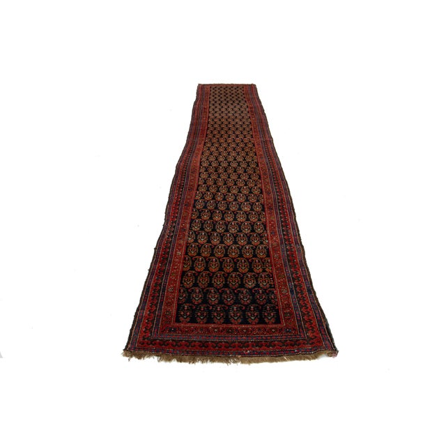 This handmade Persian Malayer wool rug dates back to the 20th century and features a dark blue field accented with red,...