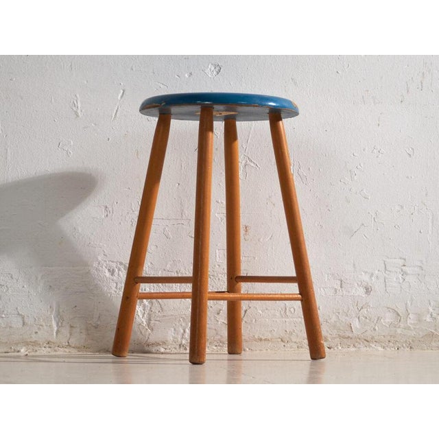 This antique wooden stool is a three-legged seat with a round seat and turned splayed legs joined by stretchers. It...