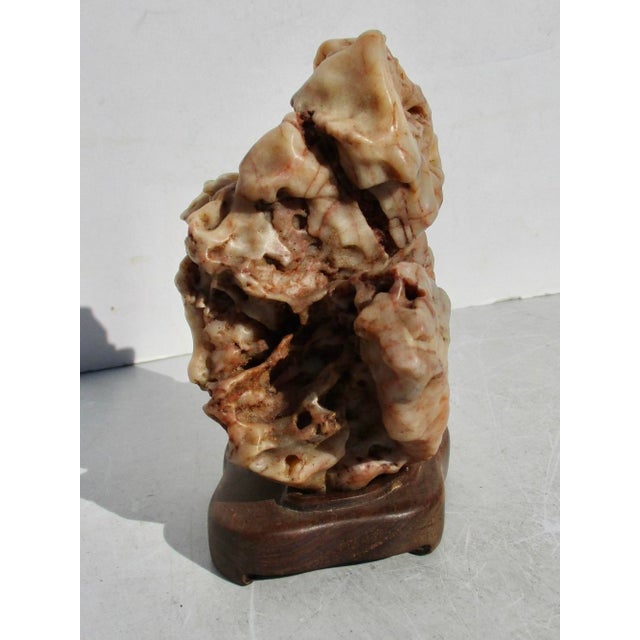 A fine scholar's stone in hardwood mounting. An intricate piece of Limestone as carved in cavern waters. Creamy, soft,...
