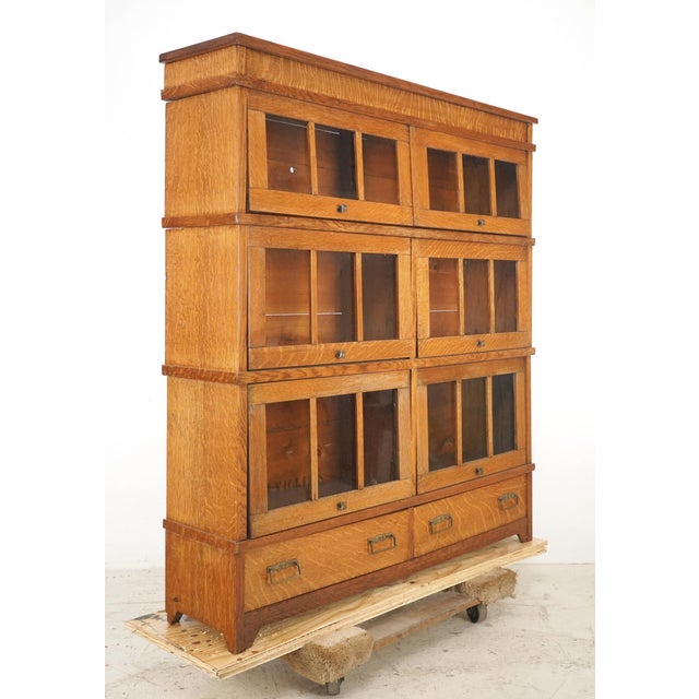 Early 20th century medium tone wood barrister bookcase with six sections, each with a lift and slide glass door. There are...