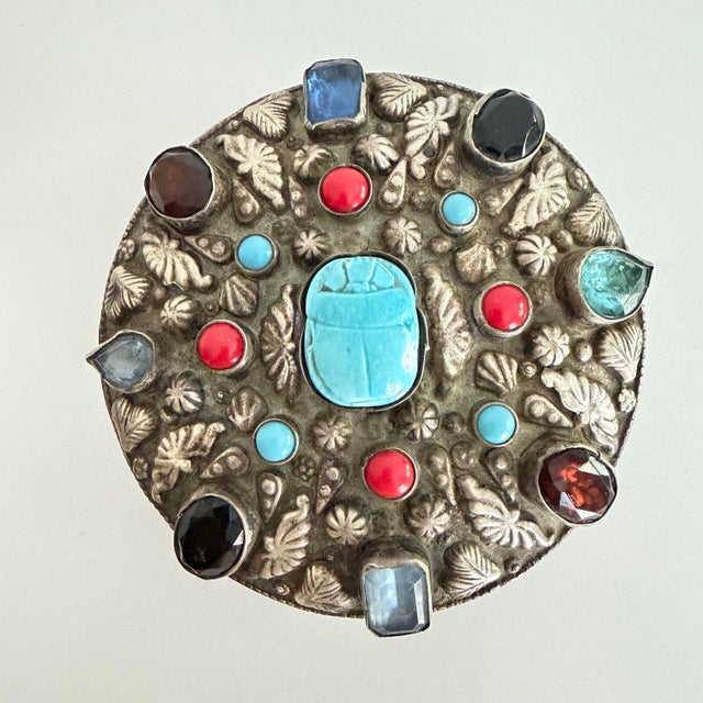 This scarab and jeweled round box has an Egyptian silver mark on the bottom and has tested 800 silver. It is at least...