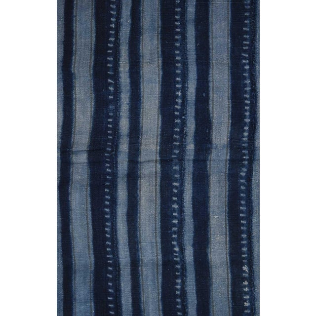 The textile is made from Indigo resist-dyed cotton. This cloth likely originates from the Dogon. Such textiles are...