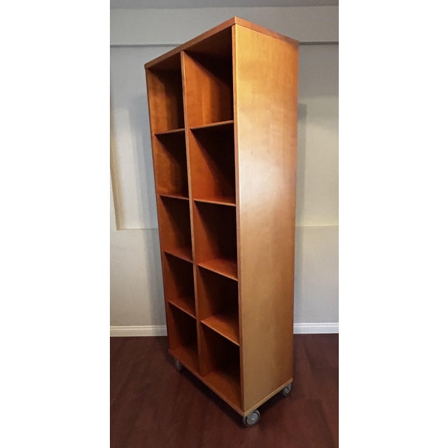 A sleek, highly functional contemporary 10-cubby architectural bookcase/shelving unit on industrial rolling wheels, circa...