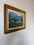 A charming vintage oil on canvas board depicting a peaceful rural farm landscape with grazing cows set against rolling...