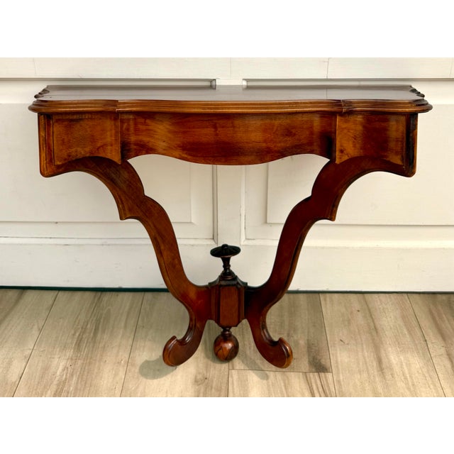 Here is a wonderful early mid-20th century wall-mounted console table with an especially beautiful sculptural silhouette....