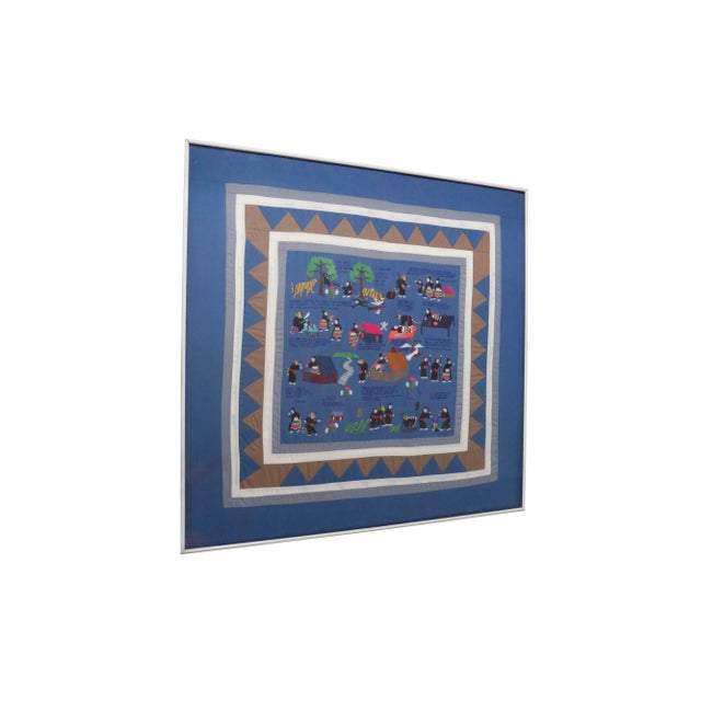 A traditional story quilt. A blue background is embroidered to tell the story of a tiger who kills and impersonates man...