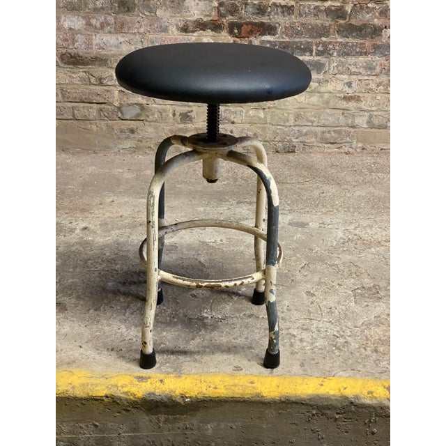 Nicely distressed paint adjustable height industrial stool. Painted steel frame with adjustable height seat. The seat has...
