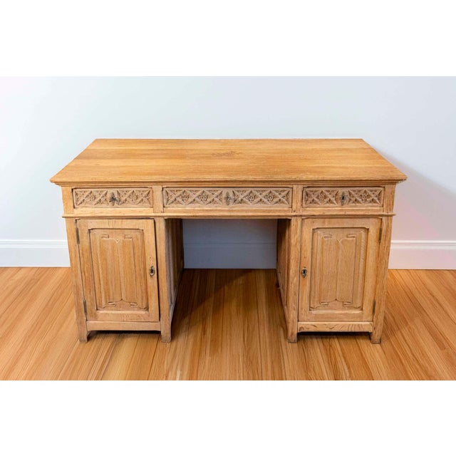 An English bleached oak Gothic Revival desk with linenfold motifs from the first half of the 19th century. This English...