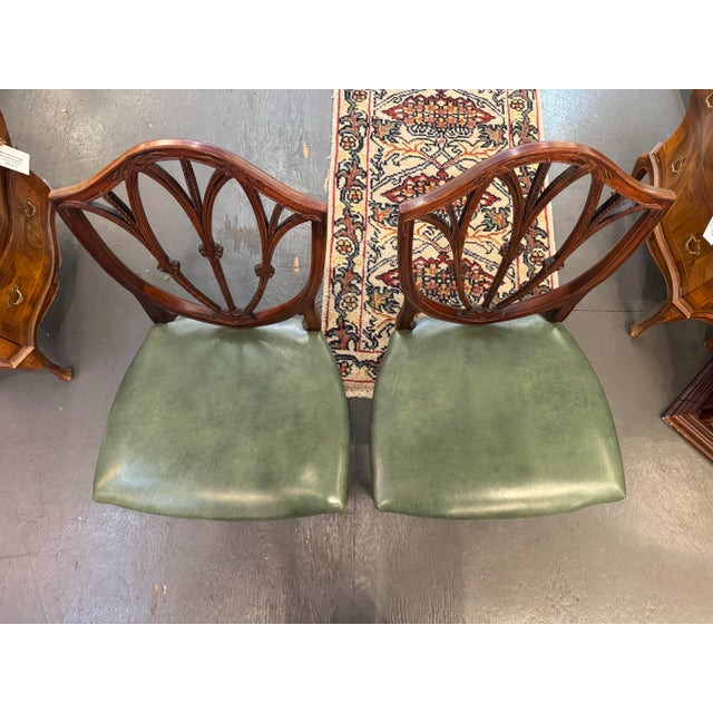 This is a set of 2 vintage shield-back mahogany side chairs. They are Hepplewhite style. They have a leather seats . They...