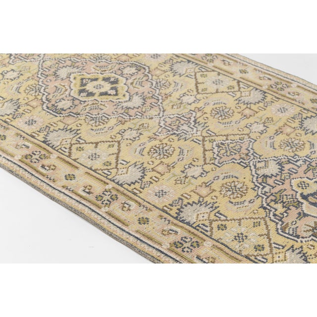 This is a vintage Turkish Oushak rug from the Mid 20th Century. The piece was hand-knotted.