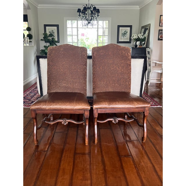 Two Dining/Accent Chairs that have a dark stain and a leather finish seat; these chairs were used as the dining head...