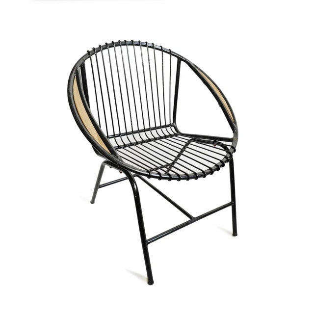Retro ring style black finish iron outdoor chair. Fun midcentury modern round shape with teak wood insert detail on arms....