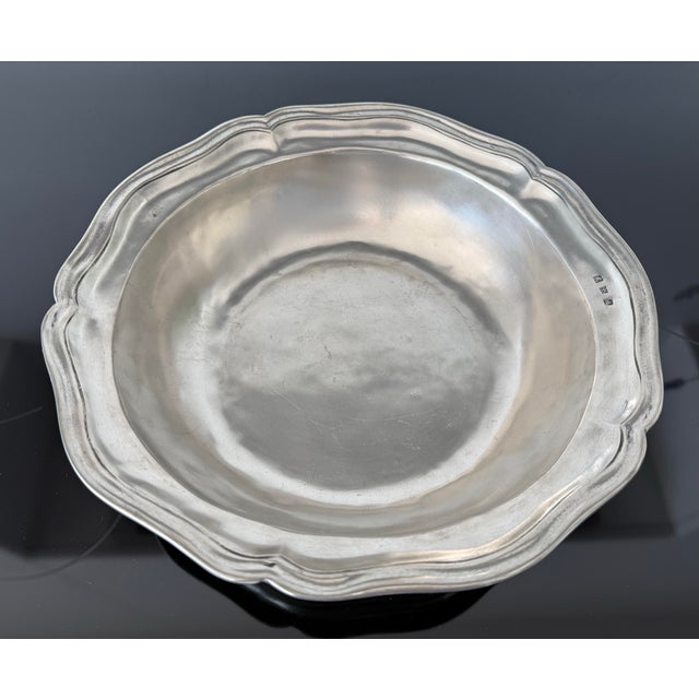 This Ralph Lauren Home “Stanton” 12.5” round pewter bowl is a discontinued serveware piece featuring a hand-hammered...