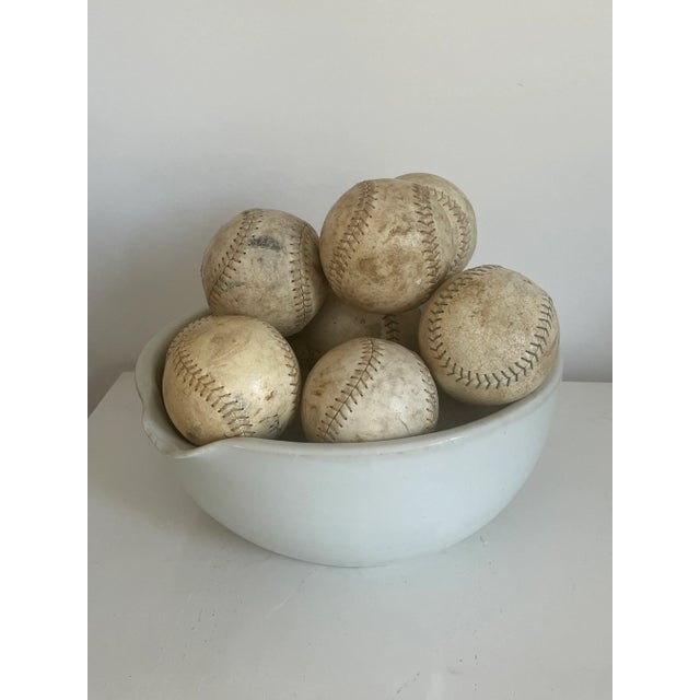 Very large white stoneware mixing bowl with spout and 15 vintage leather softballs. Bowl is heavy 15-20 lbs.