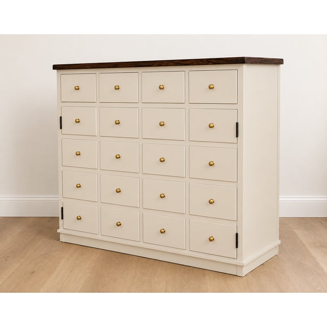 Beautifully refinished French Provincial apothecary-inspired cabinet featuring an elegant sculpted ivory finish paired...