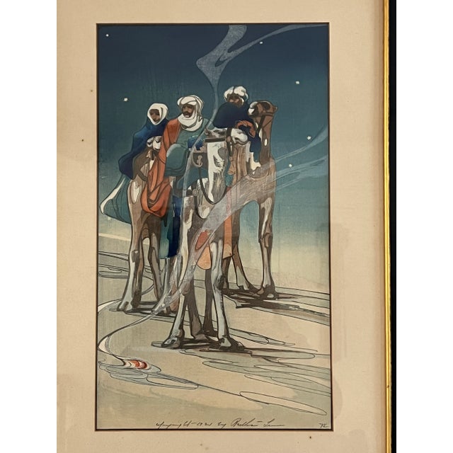 Three men mounted atop camels gazing intently into the distance at left, stars glow in the deep blue night sky above. Near...