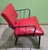 This mid-century modern chair features a striking red vinyl seat and backrest with a sturdy black metal frame. Its bold...