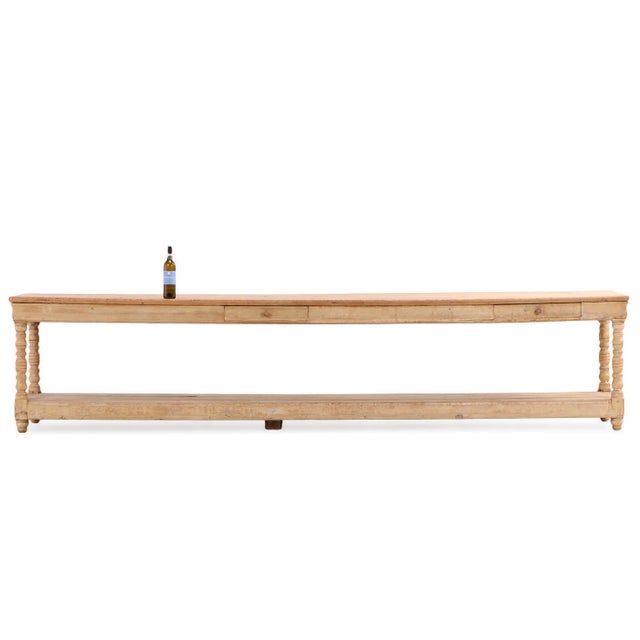Featuring two tiers supported by four turned legs, this substantial table showcases the warm patina and character of aged...
