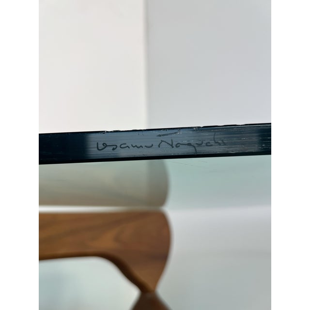 Sculptural Interlocking walnut base and a glass top.