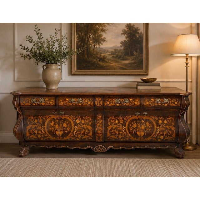 This stunning bombe-shaped credenza exudes old-world craftsmanship. Featuring intricate floral marquetry inlays across its...