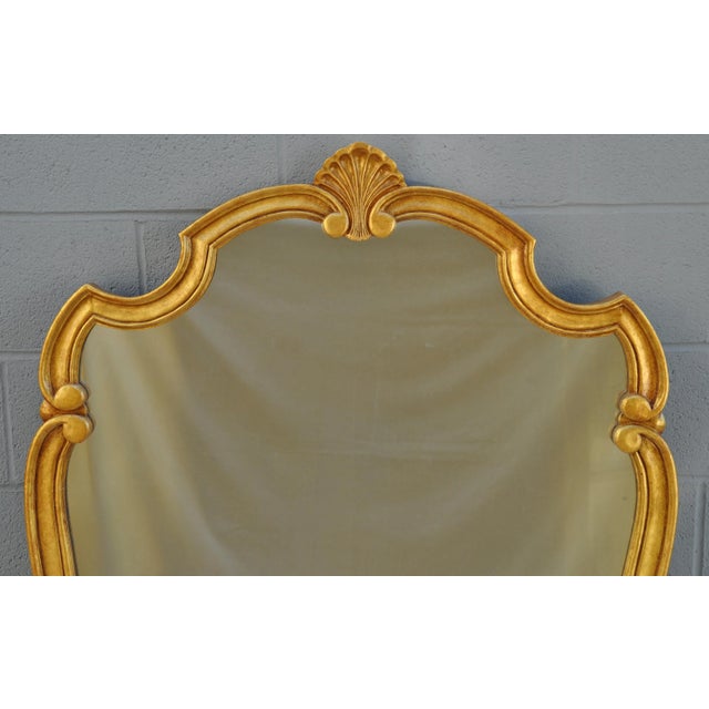 Large, glamorous, 1970s mirror with a new gold paint finish on the curvy frame. A fantastic shaped frame with a shell...