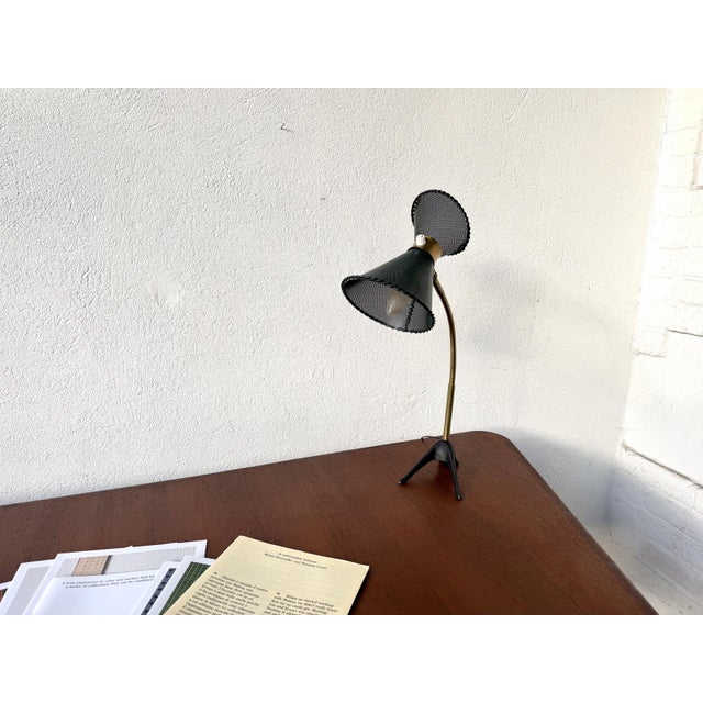 1950s diabolo desk lamp, reminiscent of Mathieu Matégot's perforated metal lighting fixtures. Two dark green lacquered...
