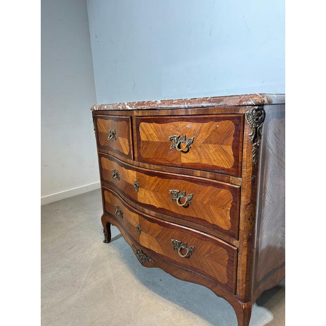 Elegant vintage chest of drawers featuring a beautiful red/brown marble top and a warm wood veneer with decorative inlay....