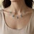 Radiating elegance and brilliance, this Swiss Blue Topaz Dangle Station Necklace features five captivating oval-cut Swiss...