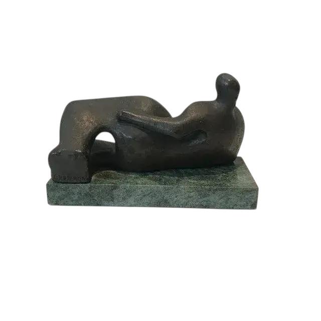 Patinated gold leaf over plaster sculpture with marble base of a Henry Moore reclining figure from the collection of the...