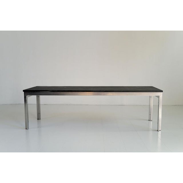 The PK-57 coffee table by Poul Kjærholm for E. Kold Christensen is made of satin-finished metal with a natural slate top....
