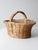This is a vintage woven harvest basket with a wide, short handle and a soft pink stripe woven through the center. The...