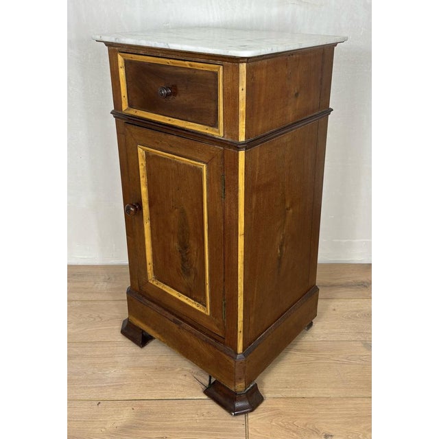 Elegant pair of Spanish nightstands featuring white marble tops, a single upper drawer, and lower cabinet doors with...
